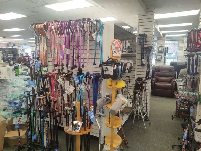 Inside a medical supply store, display of various walking canes in multiple colors.