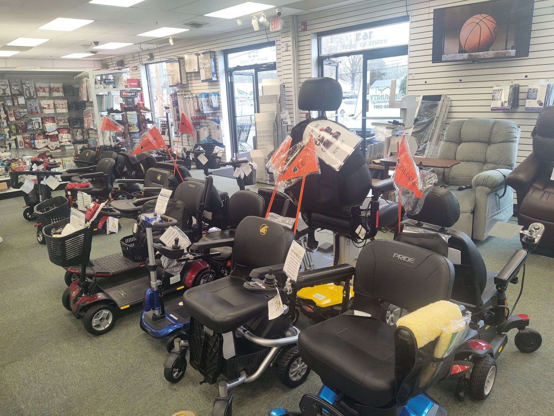 A showroom with various mobility scooters and wheelchairs on display, inside a store.