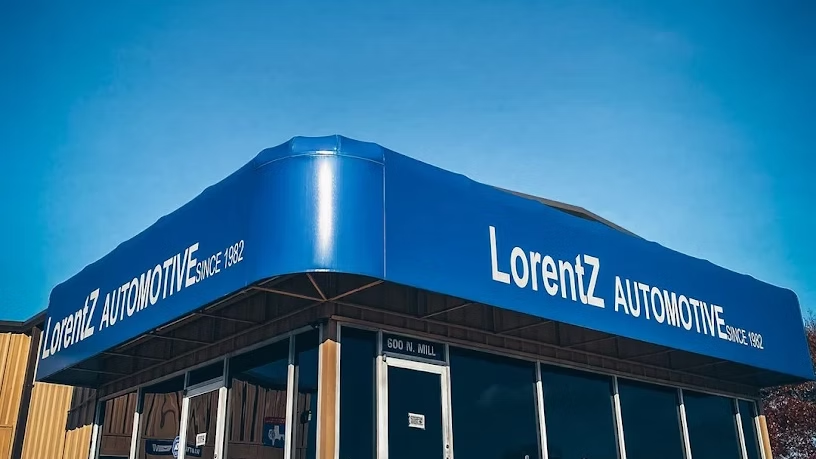 Lorentz Automotive dealership with a blue awning and glass storefront under a clear sky