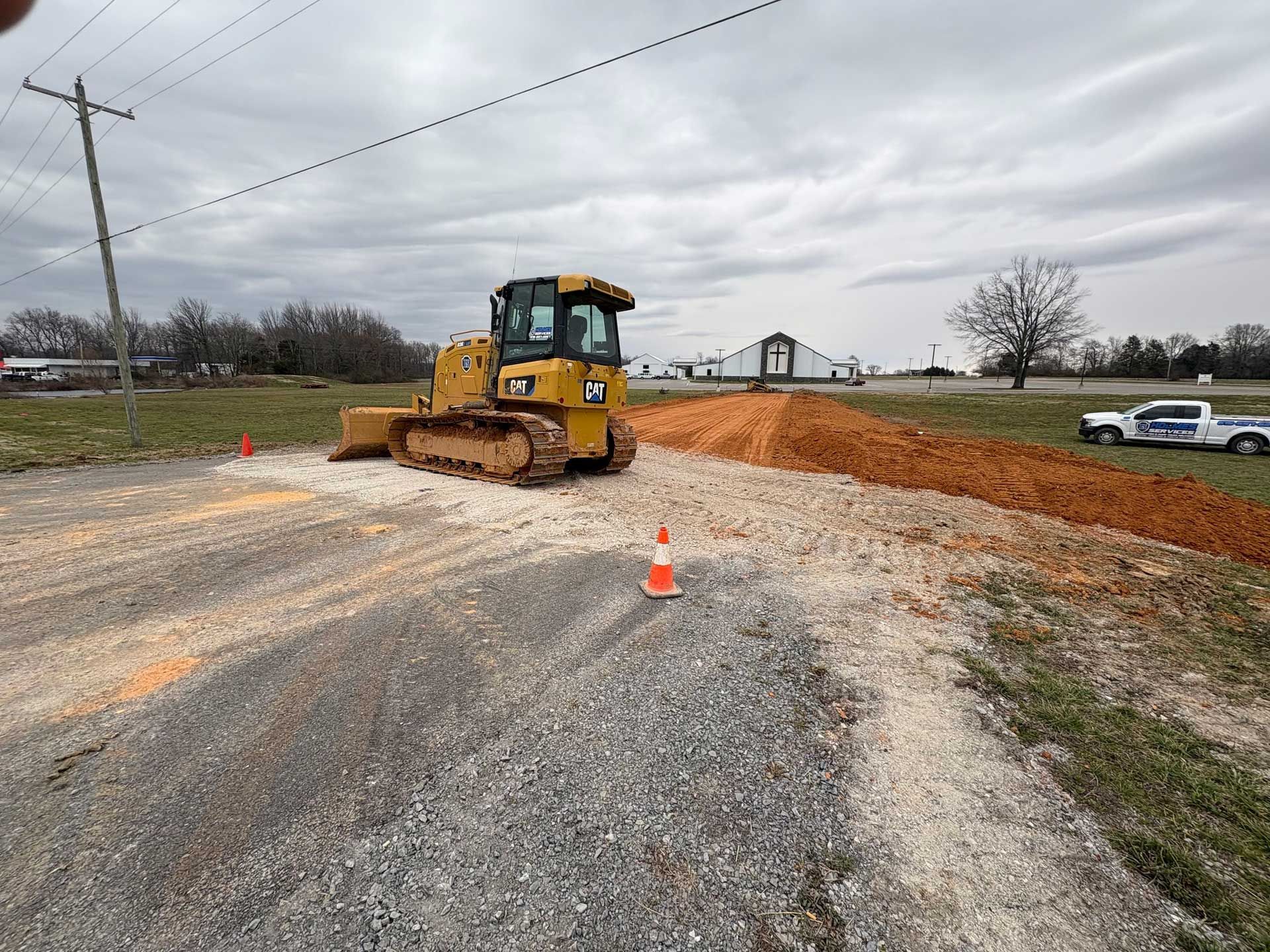 A yellow bulldozer is driving down a dirt road.