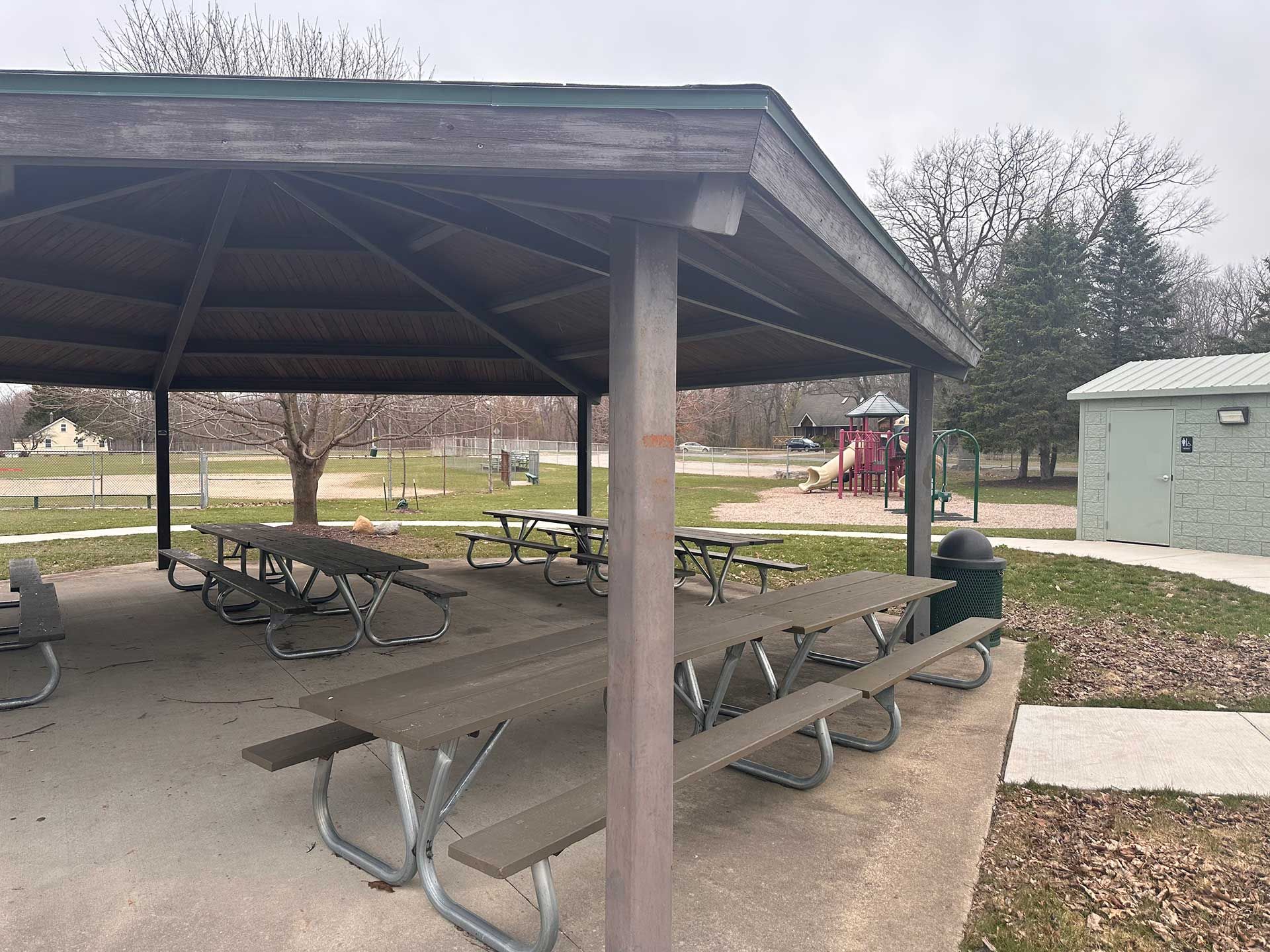 picnic tables under a covered shelter in a park