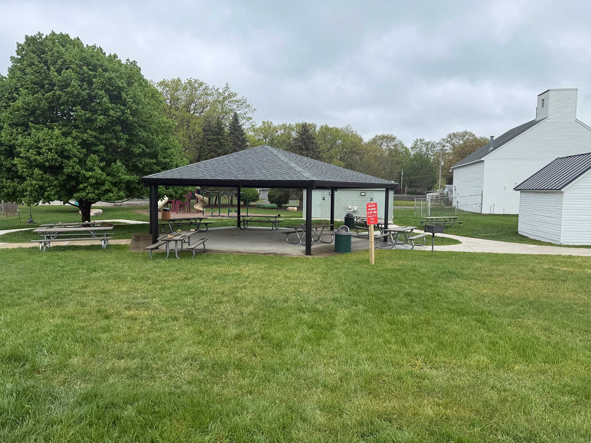 a picnic area in a park with a gazebo and picnic tables