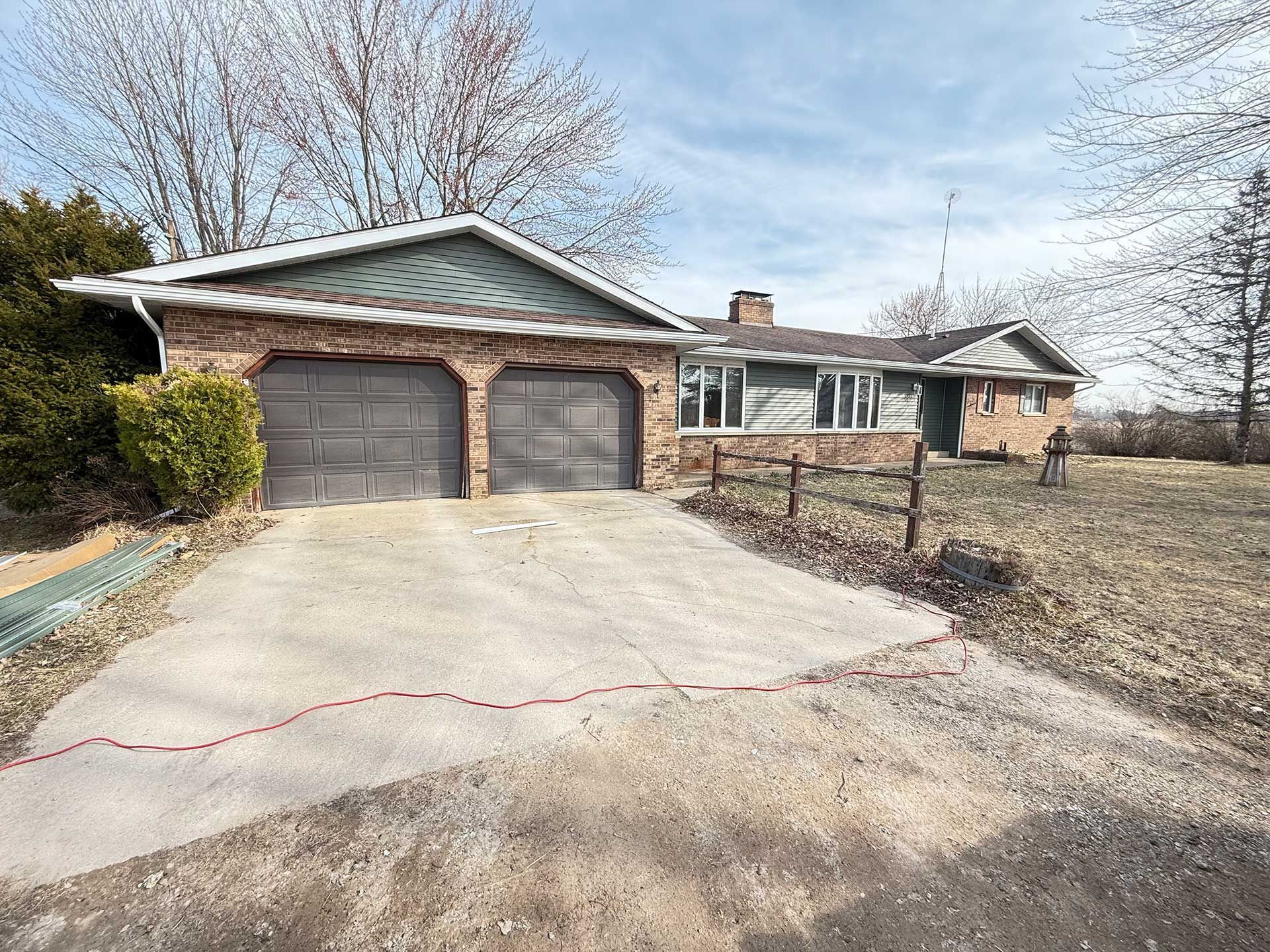 a house with two garage doors and a driveway in front of it