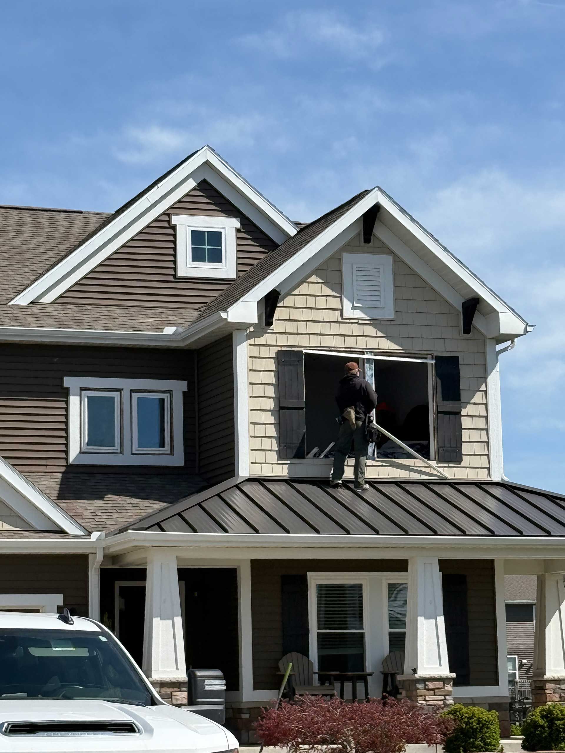 a man is working on the roof of a house