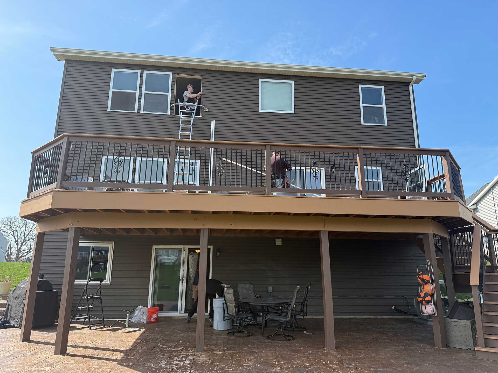 the back of a house with a large deck and stairs