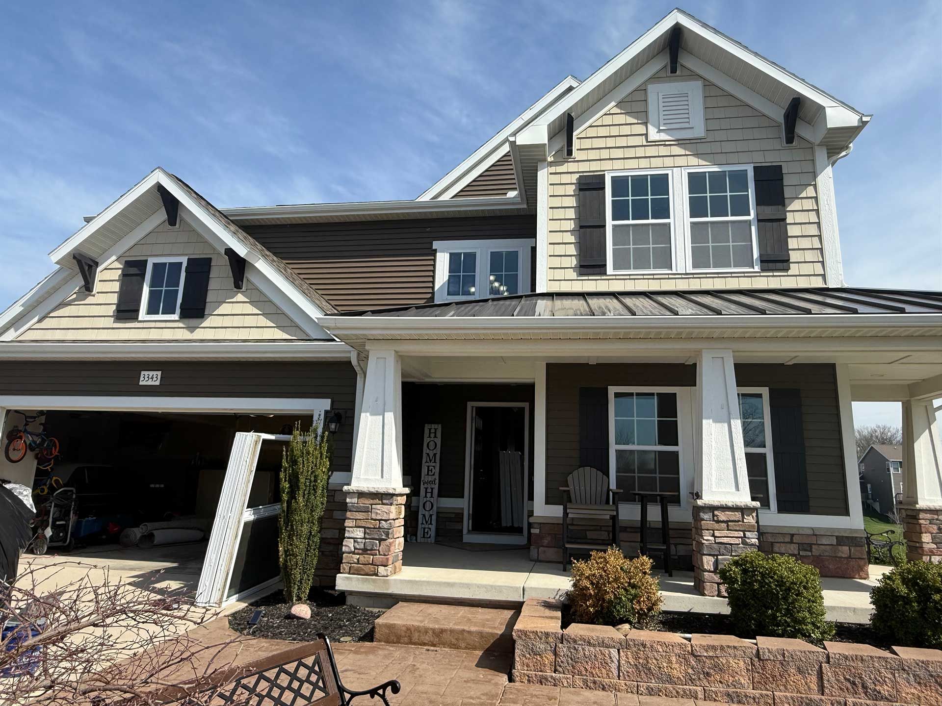 a large house with a porch and a large garage