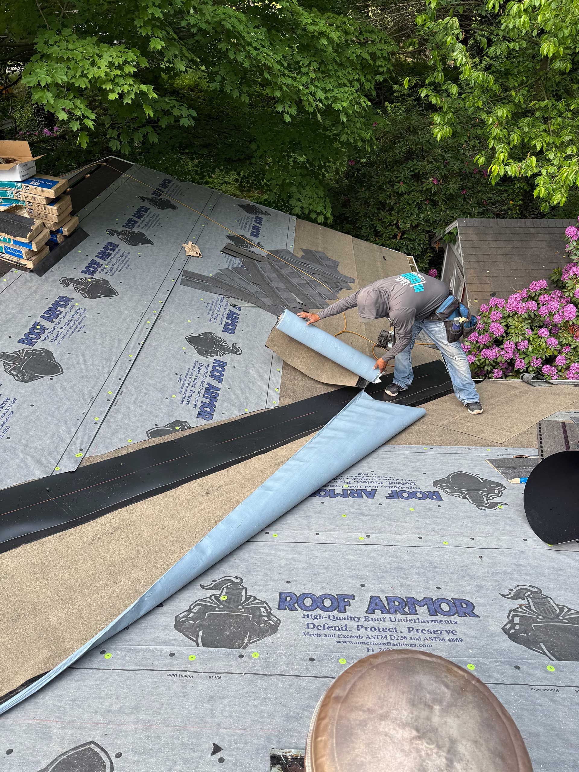 a man is laying roof shingles on top of a roof