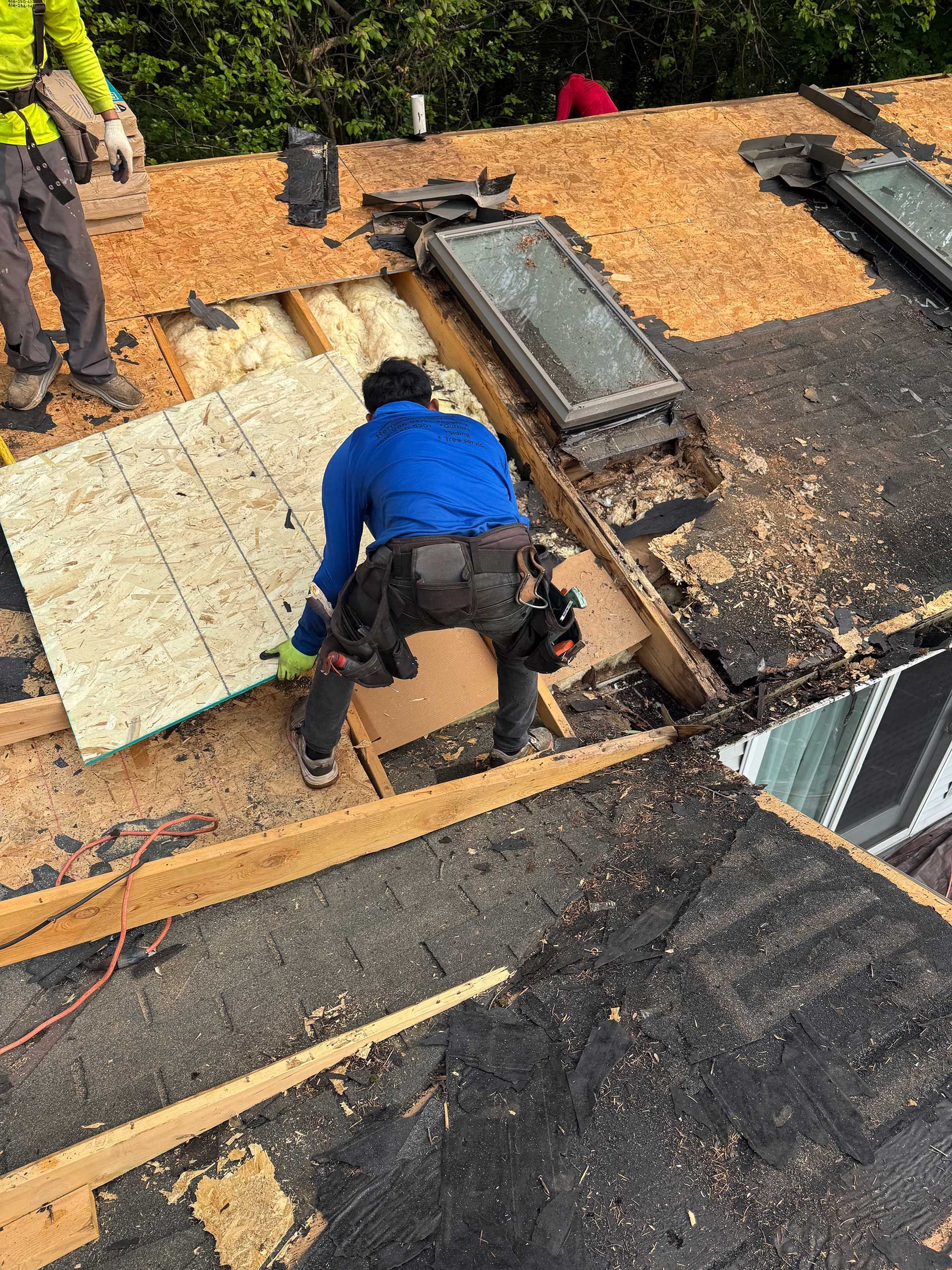 a man is working on the roof of a house