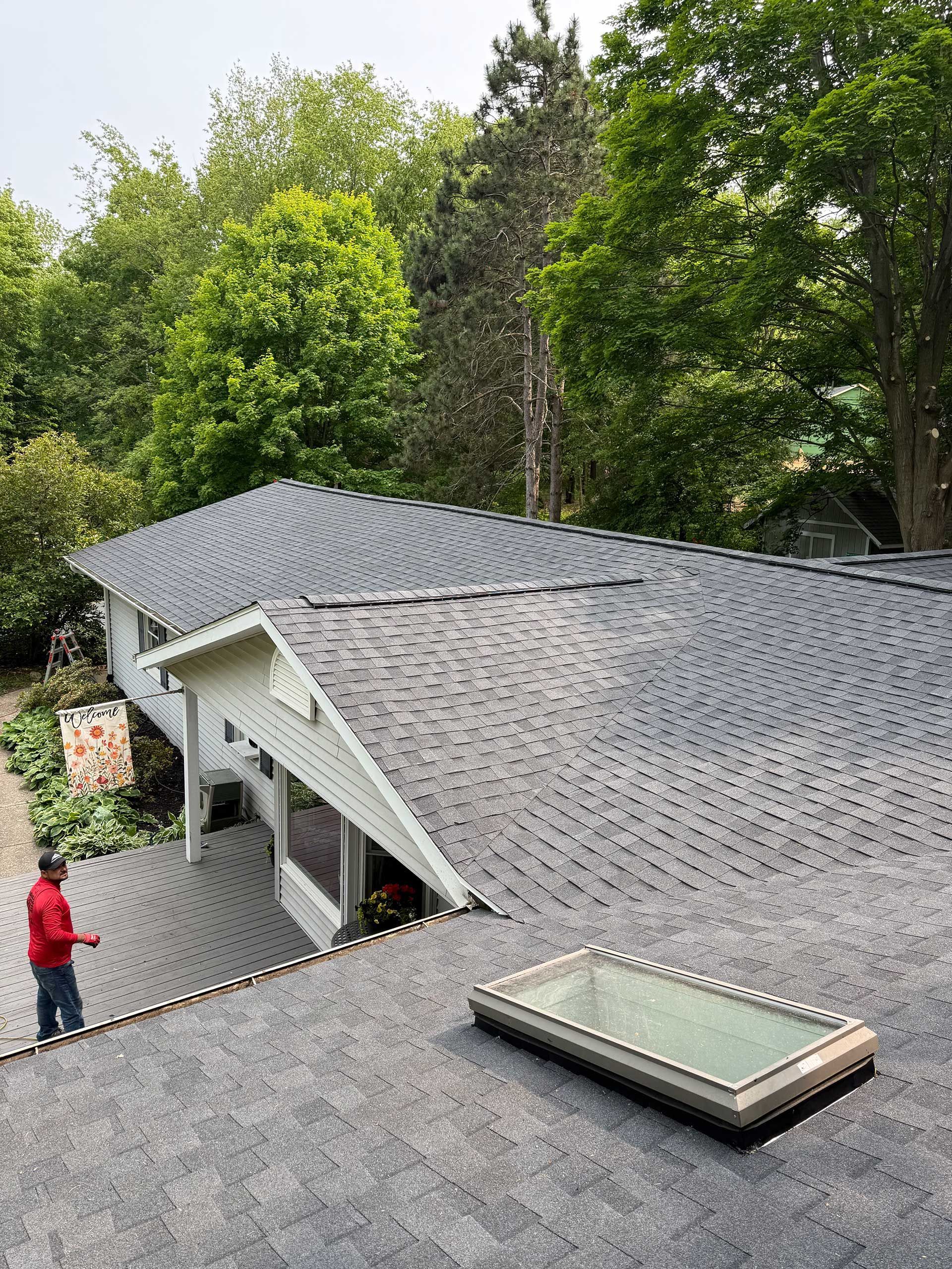 a man is standing on the deck of a house with a skylight