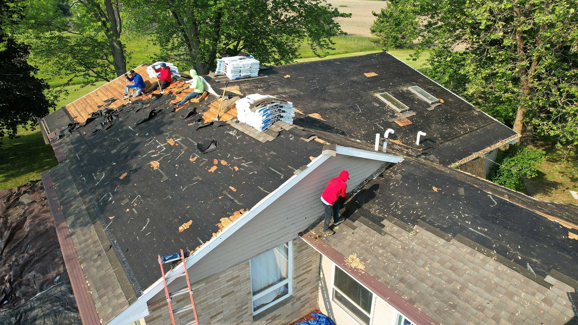 a group of people are working on the roof of a house