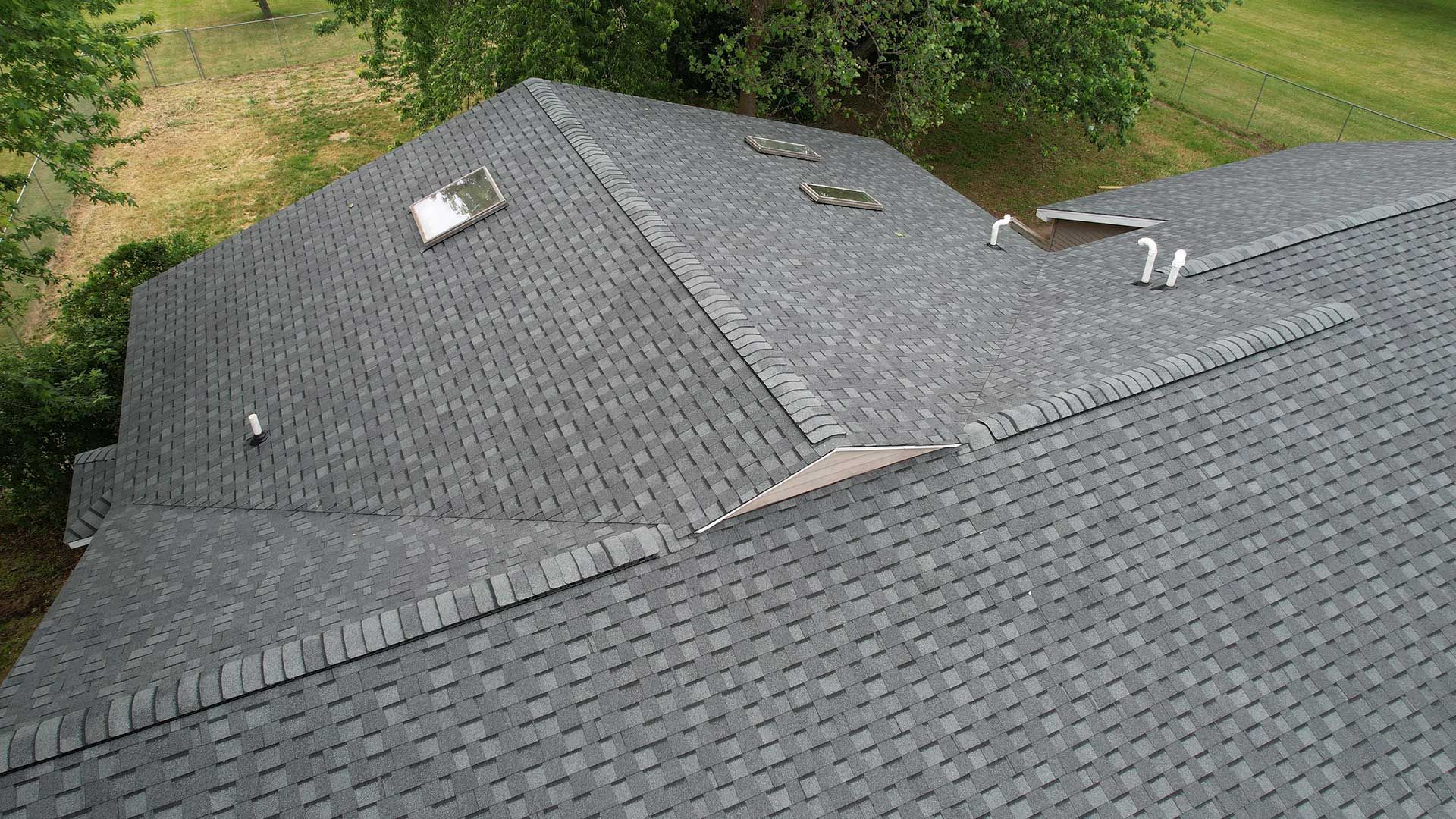 an aerial view of a roof with shingles and a skylight