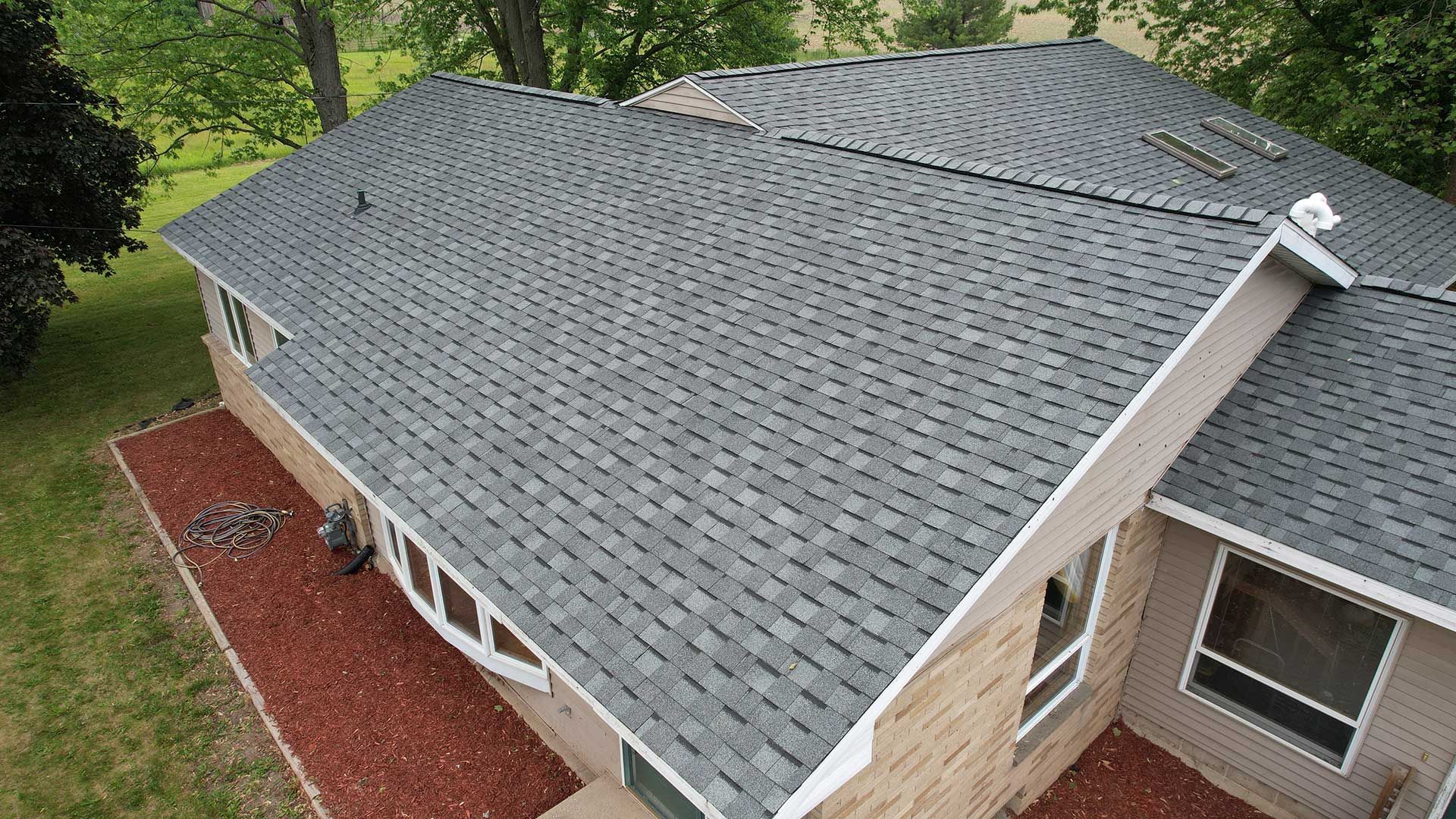 an aerial view of a house with a gray roof