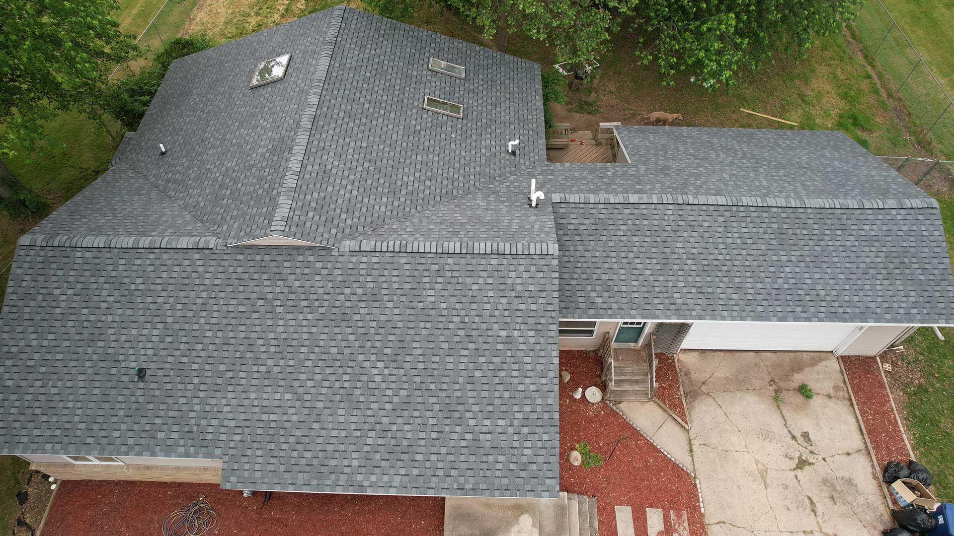 a house with a gray roof surrounded by trees