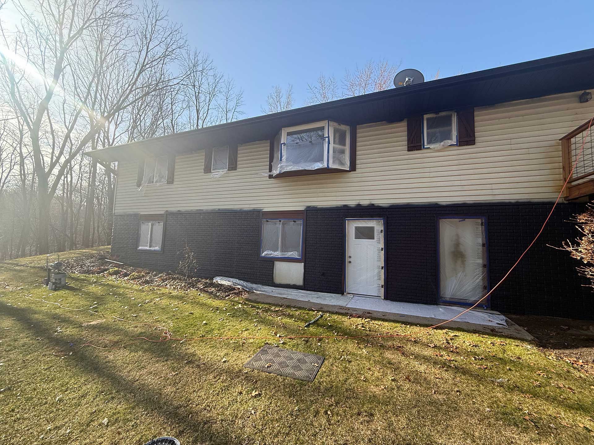 a large house with a lot of windows is sitting on top of a lush green hillside