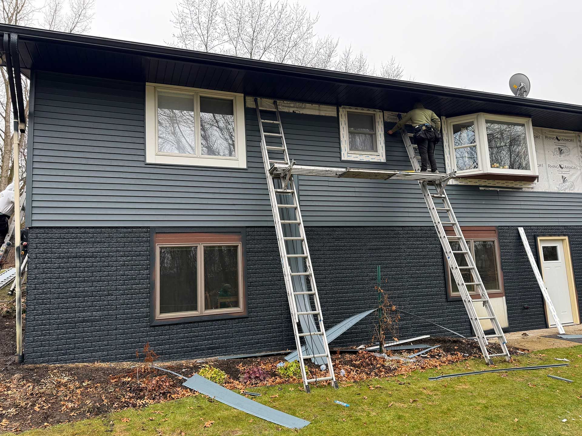 a man is installing the siding of a house