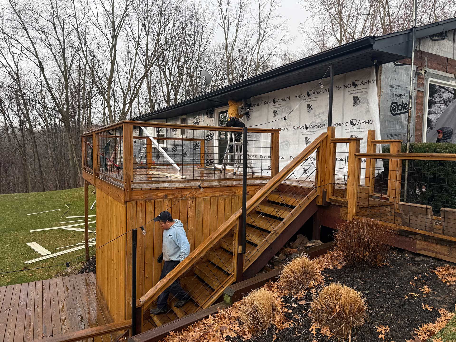 a man is walking on the stairs of a wooden deck