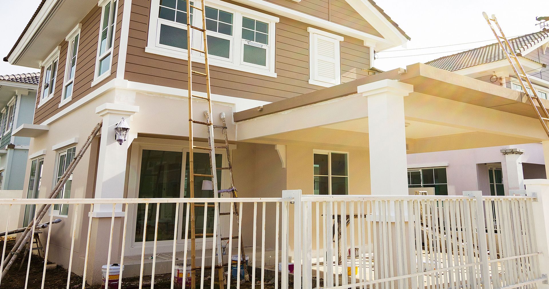 A house is being painted with a ladder on the roof.
