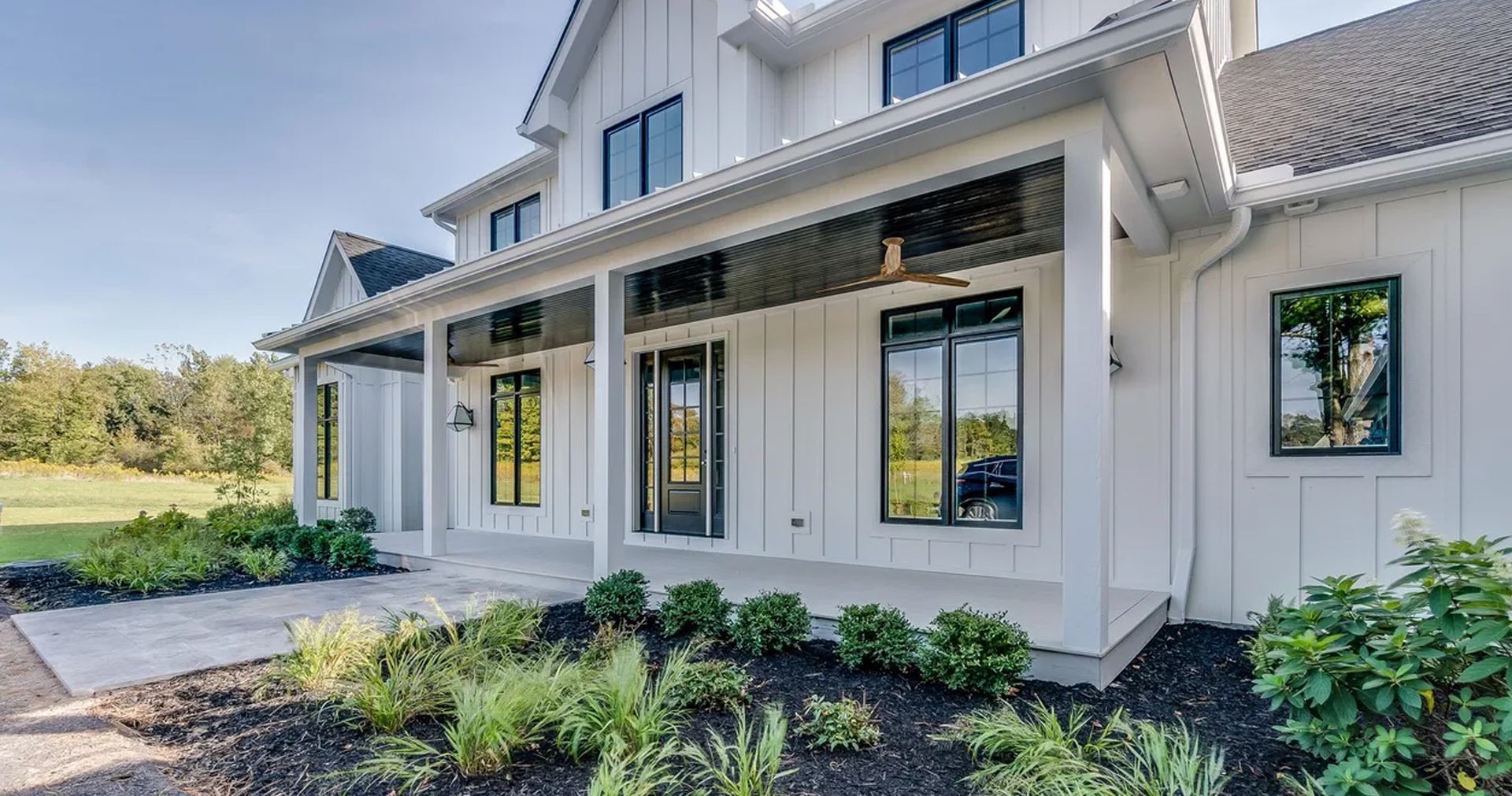 A large white house with a large porch and lots of windows.