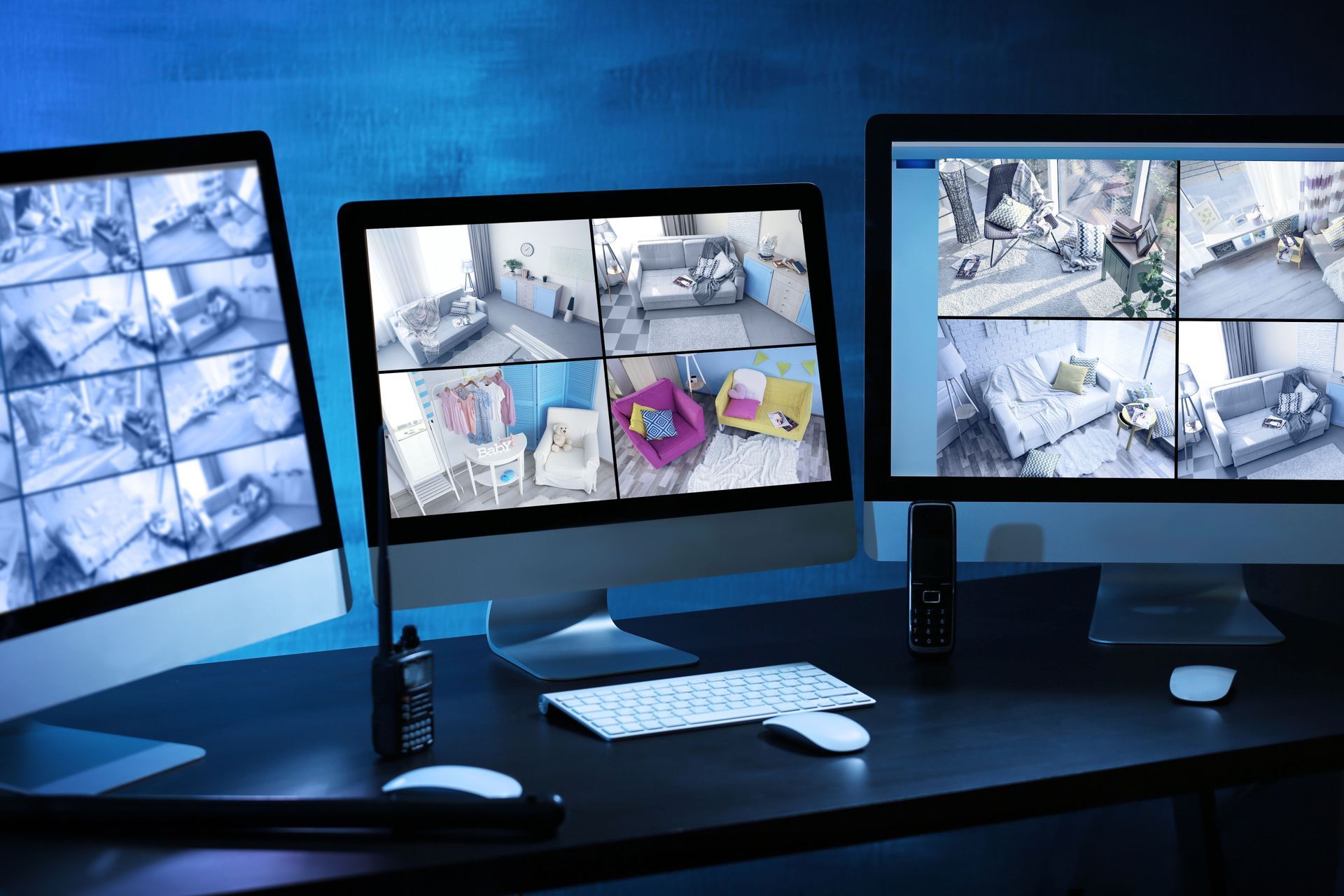 Security monitors displaying multiple camera feeds in a dark room.