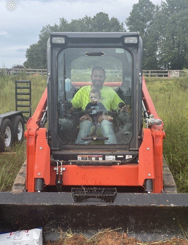 A man is driving a bulldozer in a field