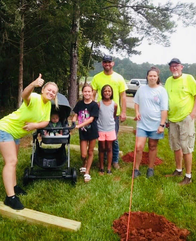 A group of people posing for a picture with a baby in a stroller.