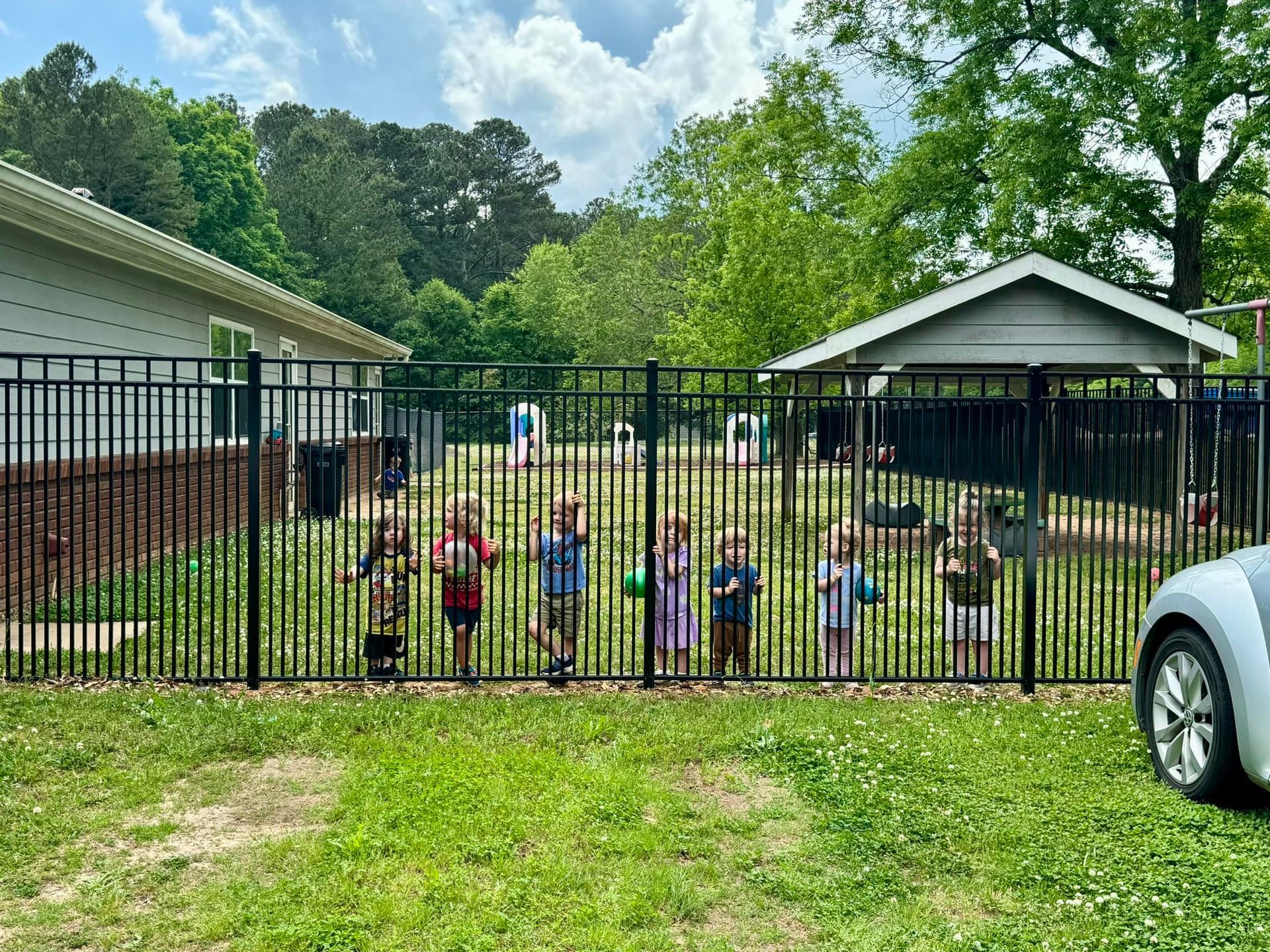 kids standing behind the fence