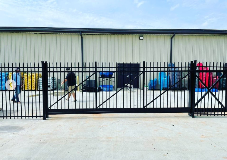 A fence with a sliding gate in front of a building