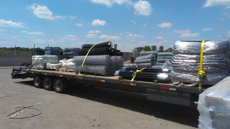A semi truck is loaded with a lot of supplies on a trailer