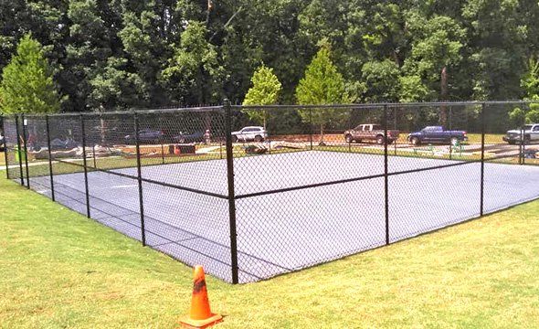 A tennis court with a chain link fence around it