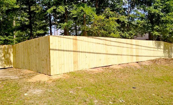 A wooden fence is sitting on top of a grassy hill.