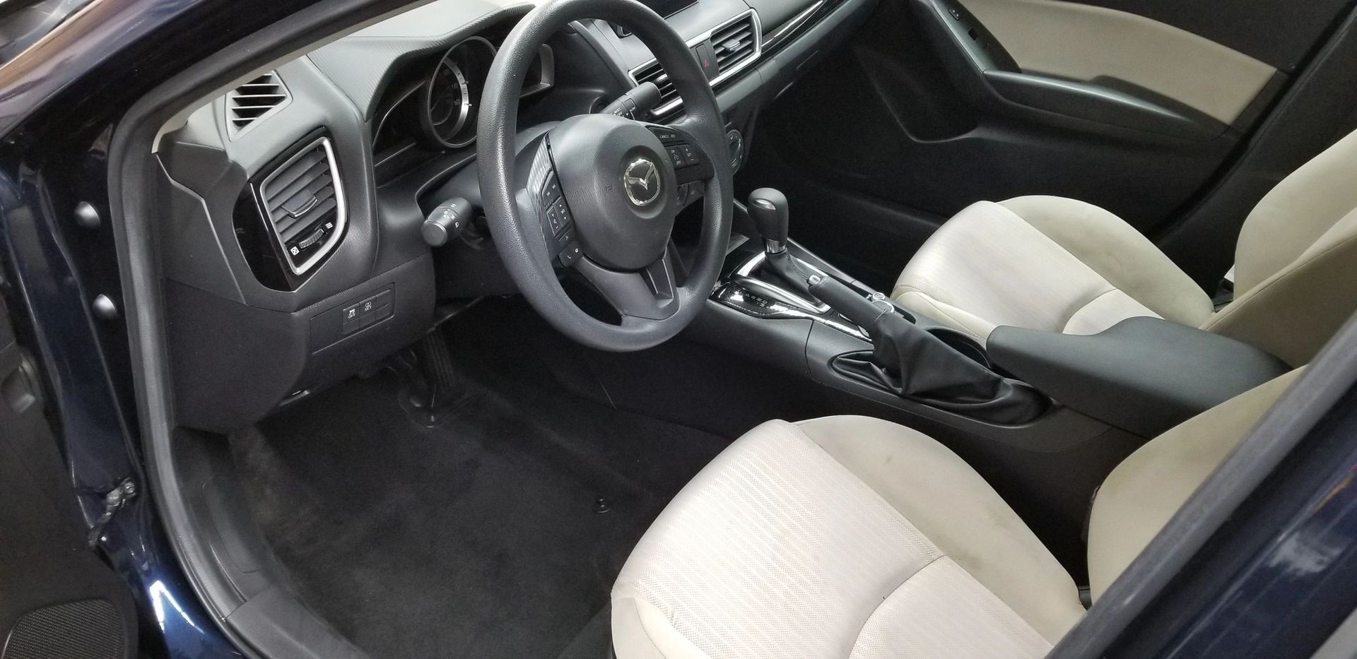 The interior of a car with a steering wheel and seats