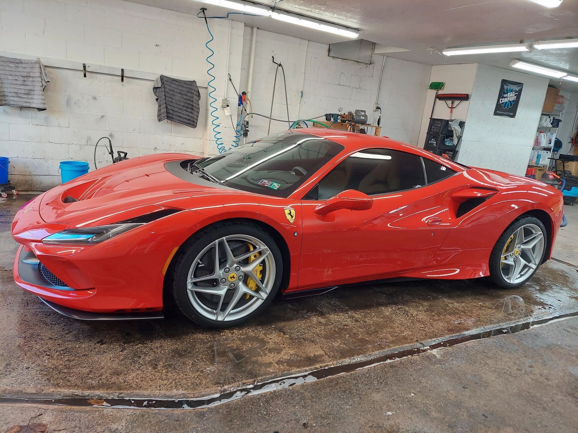 A red ferrari is parked in a garage.