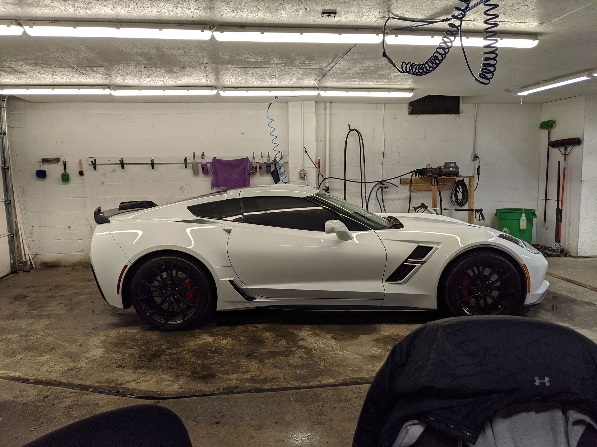 A white sports car is parked in a garage.