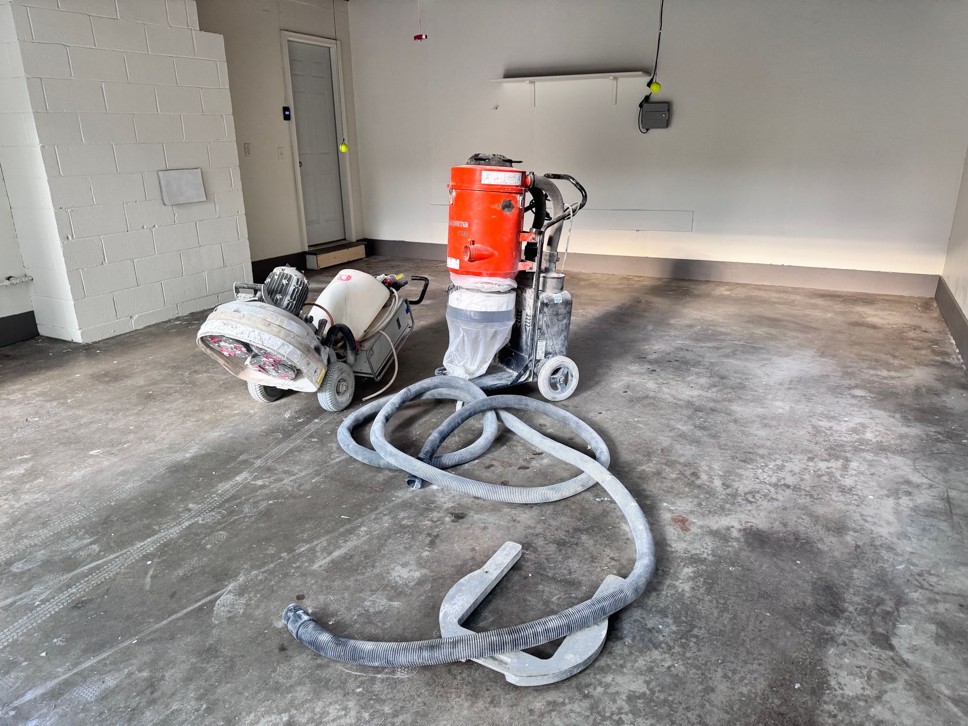 Garage with concrete floor grinders and vacuum system.