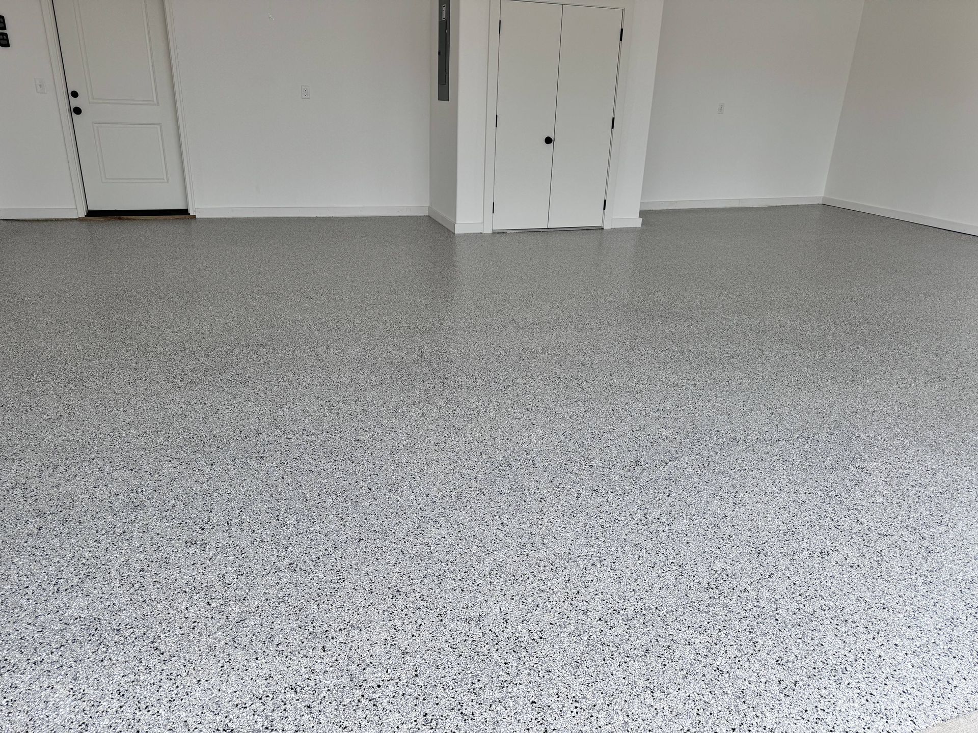 Gray and white speckled epoxy floor in a white-walled room with two doors.