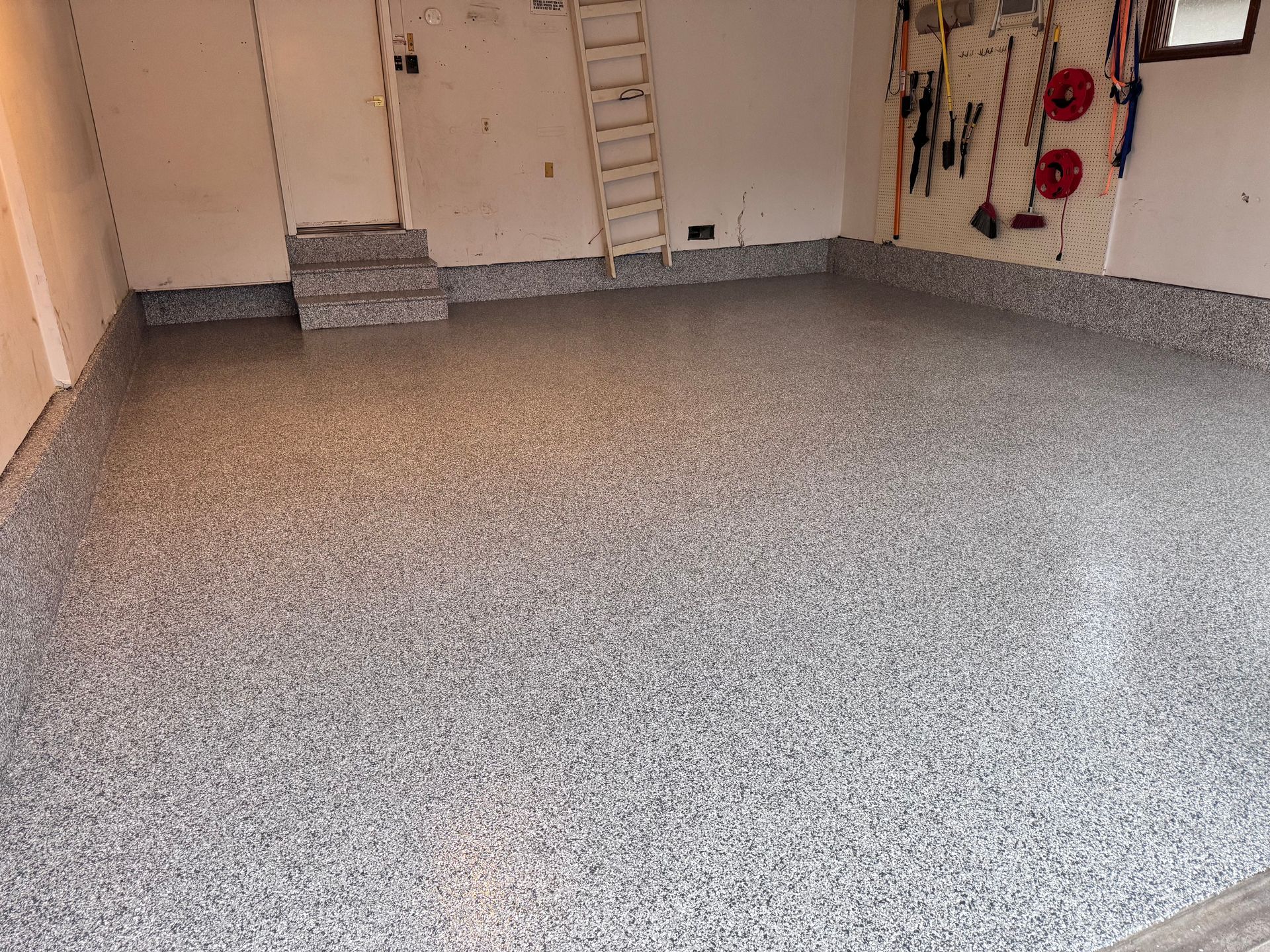 Garage with a speckled gray epoxy floor.
