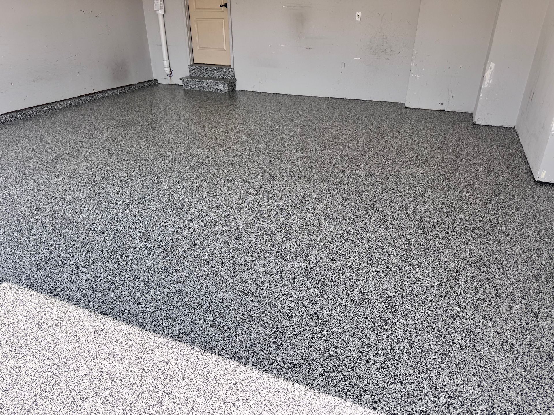 Garage with a speckled gray epoxy floor.