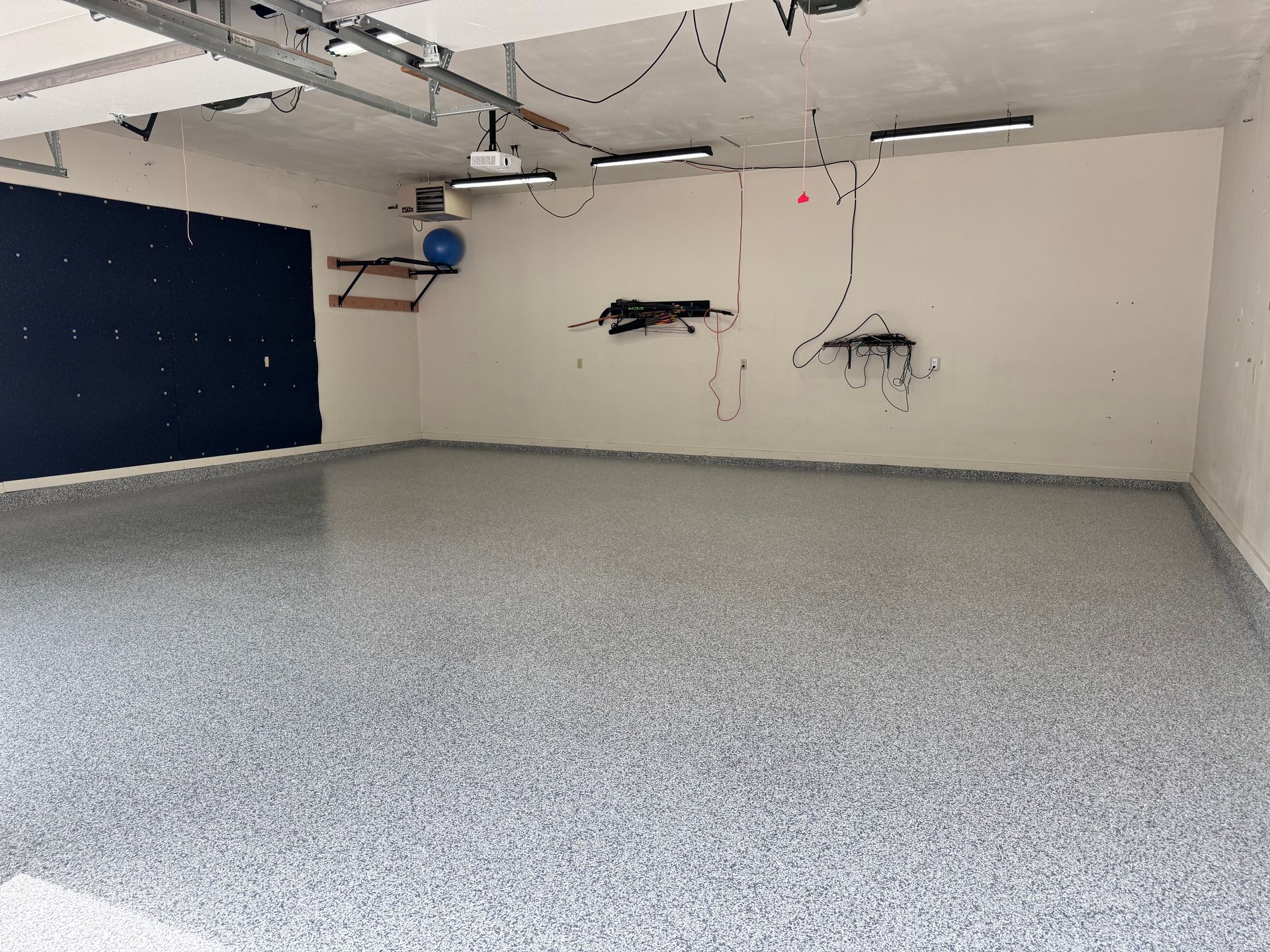 Garage interior with gray speckled epoxy floor and white walls.