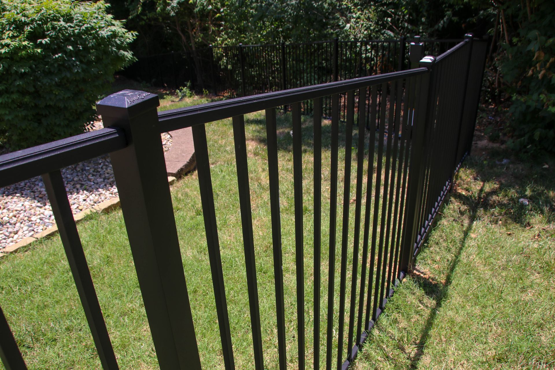 Black metal fence in a green yard.