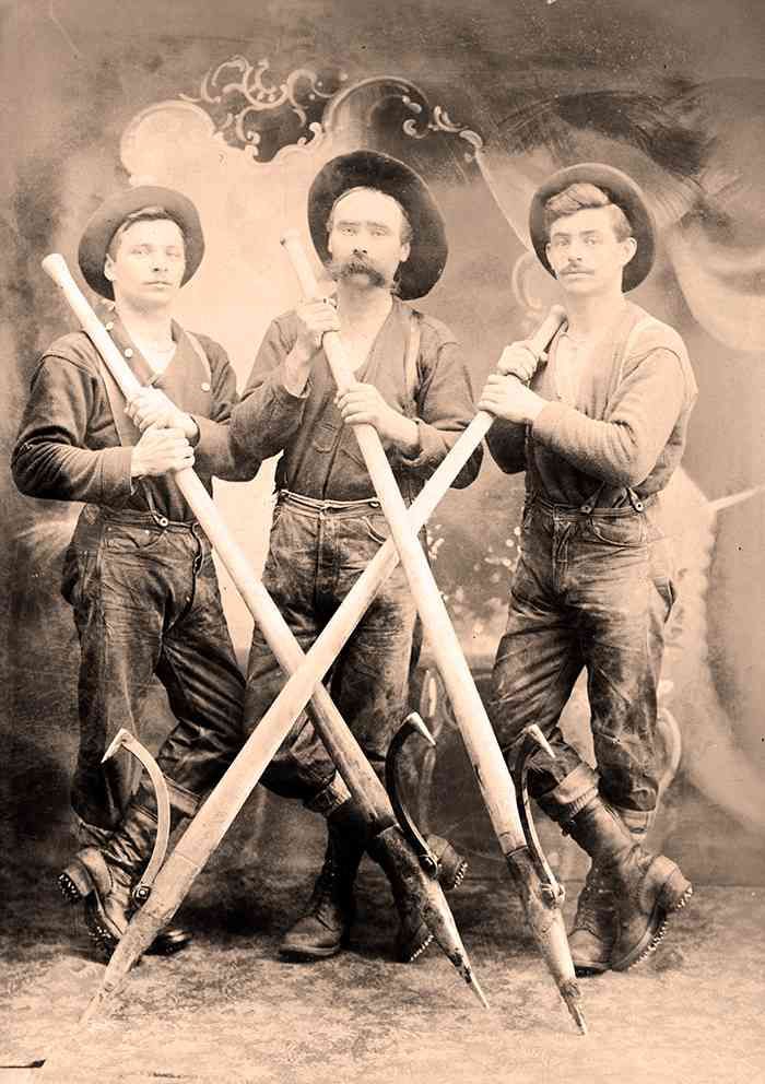 Three people in vintage clothing pose with crossed swords in a sepia-toned studio portrait.