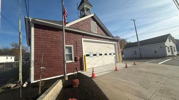 A fire station with a flag flying in front of it.
