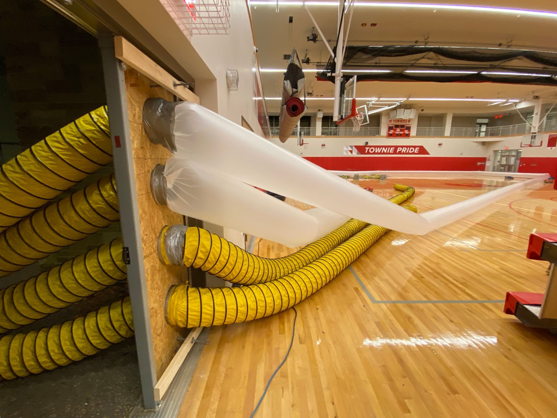 A basketball court with a bunch of yellow hose attached to it