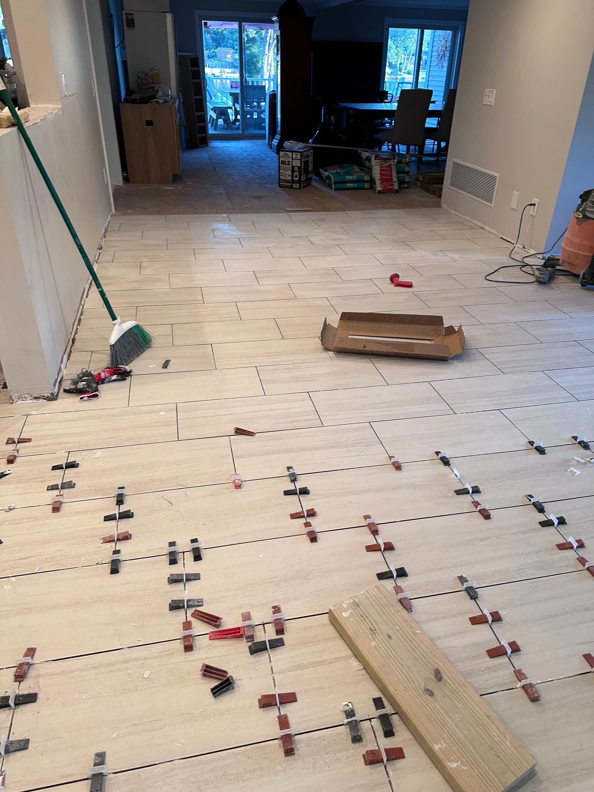 A tile floor is being installed in a living room.