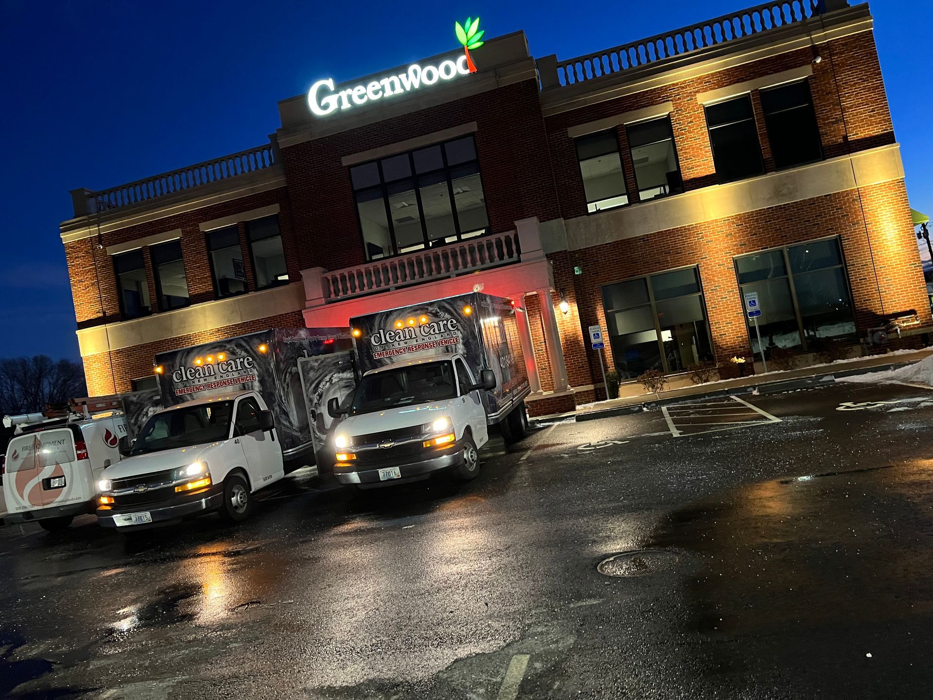 Three food trucks are parked in front of a building.