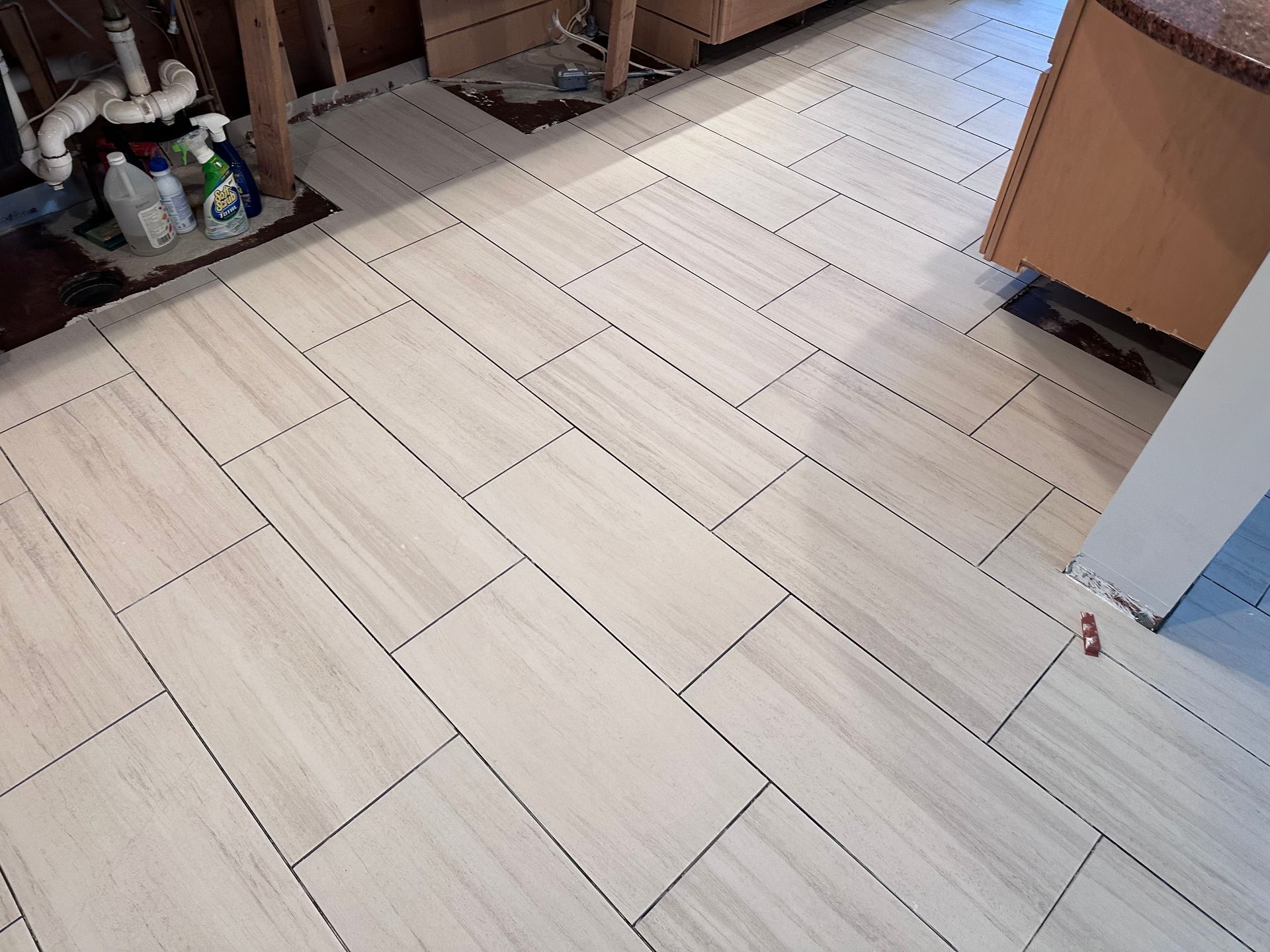 A kitchen with a tiled floor and a sink