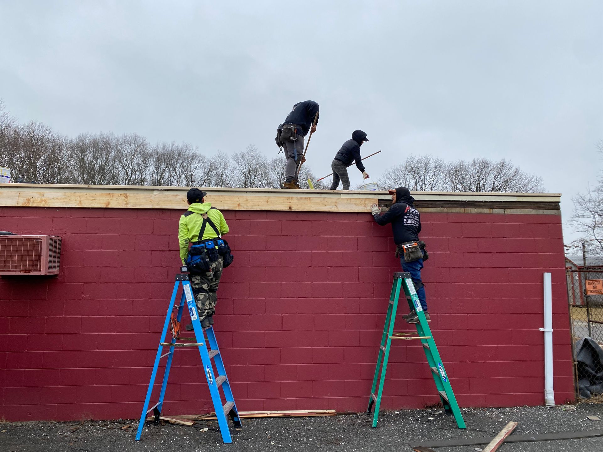 A group of men are working on the roof of a building.