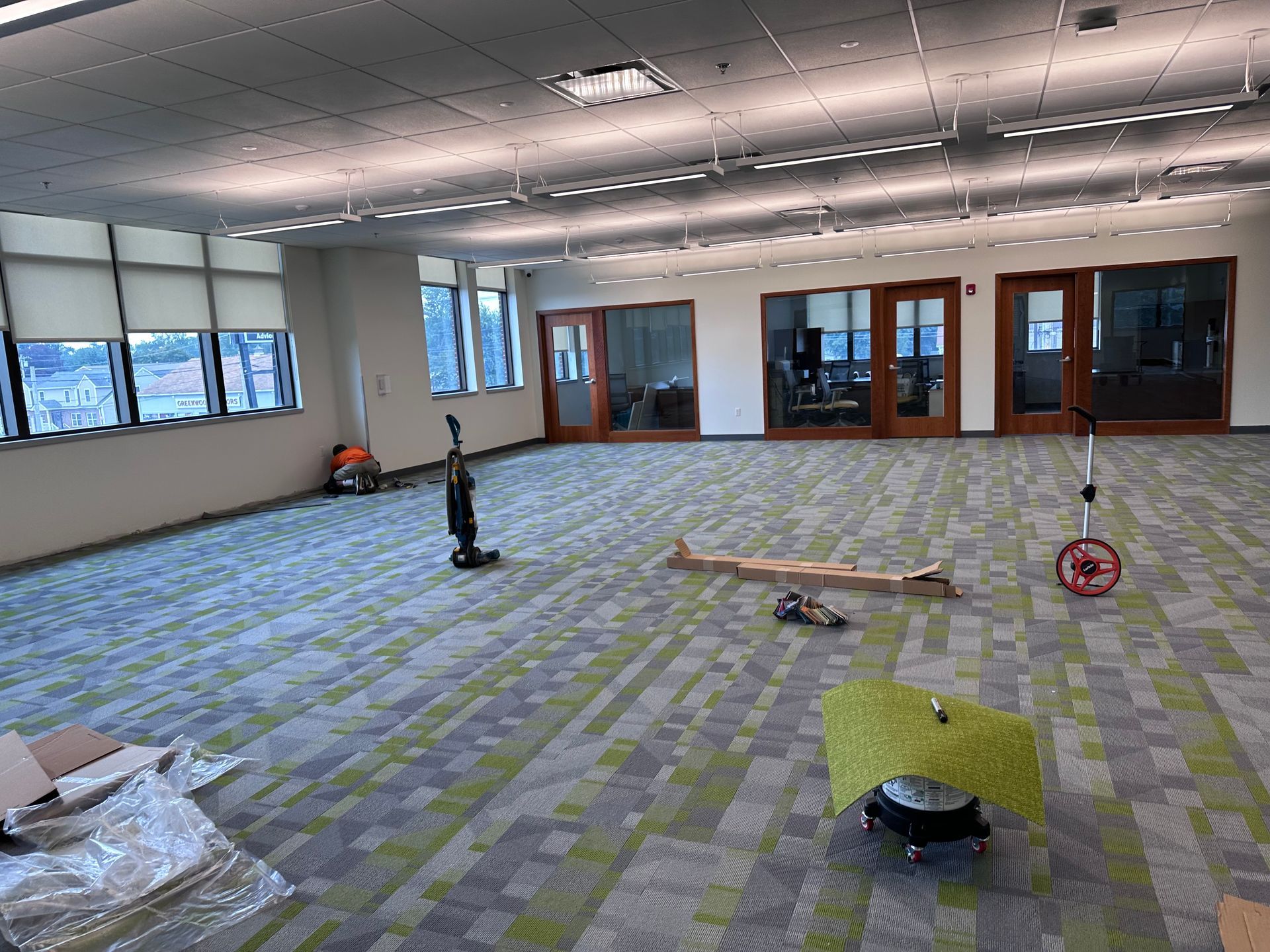 An empty room with a vacuum cleaner and a scooter on the floor.