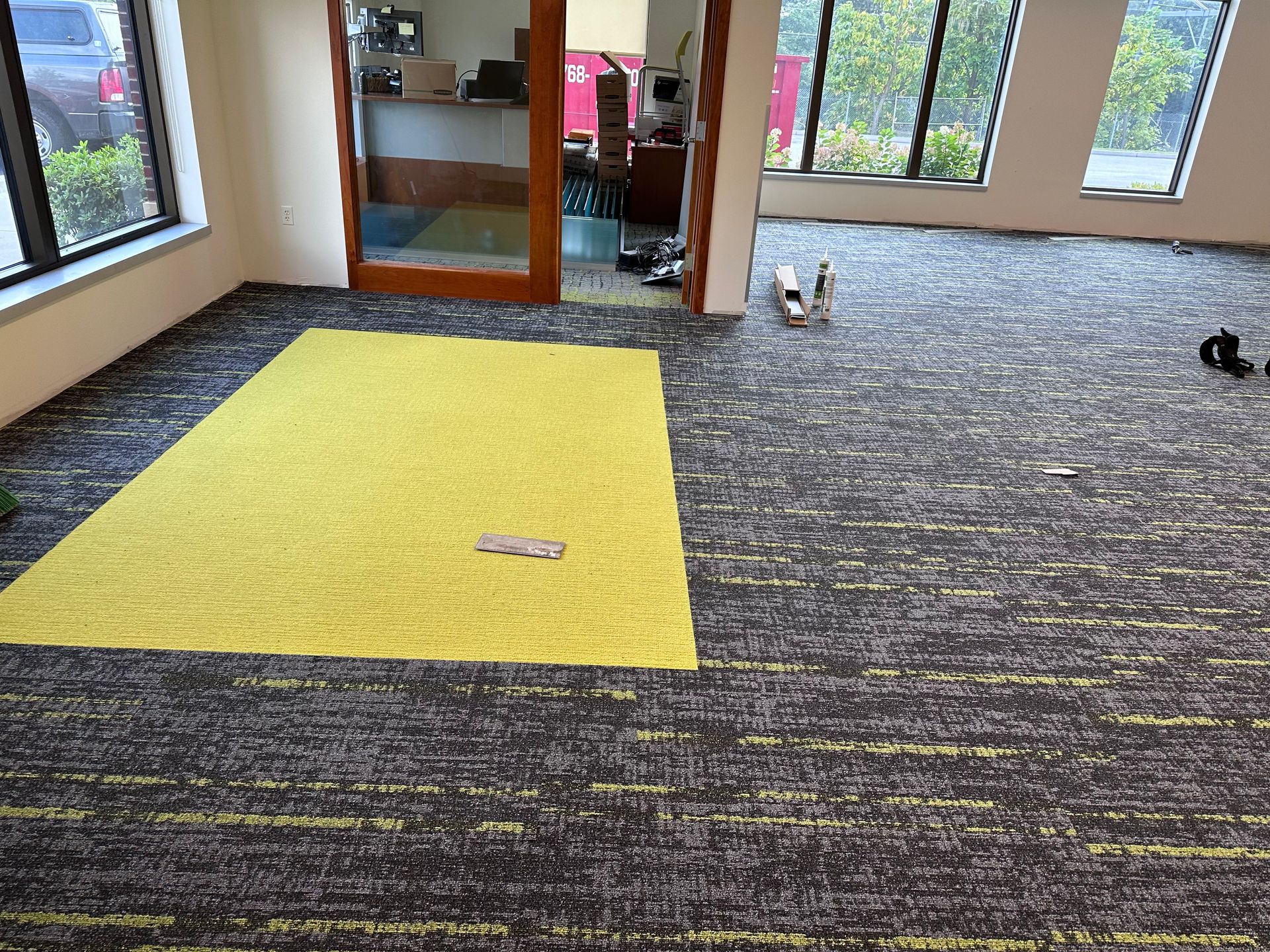 There is a yellow rug on the floor in the middle of the room.