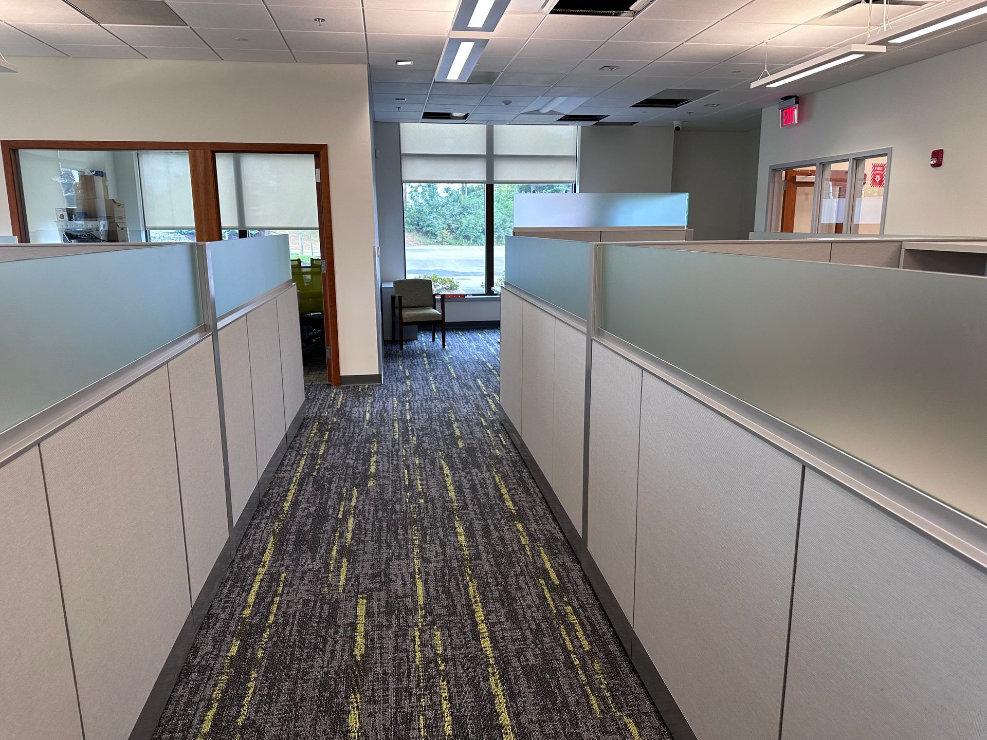 A long hallway with cubicles in an office building