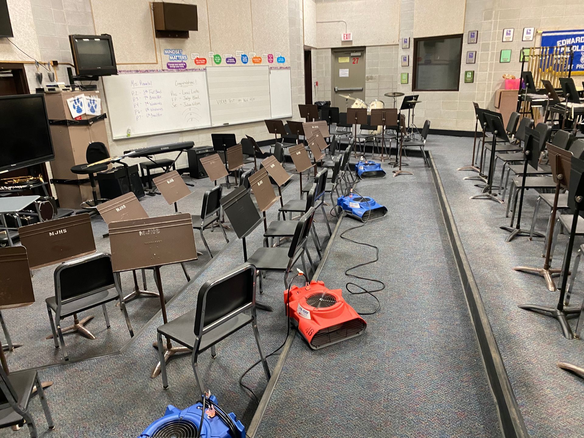 A classroom with a lot of chairs and instruments in it.
